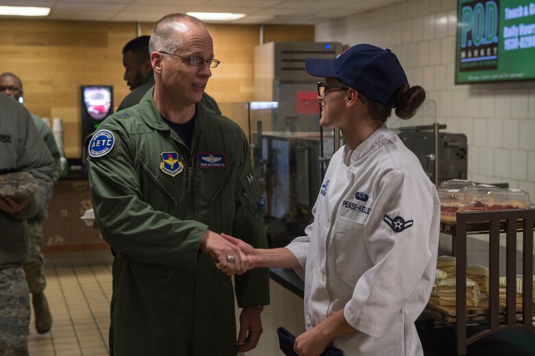 U.S. Air Force Maj. Gen. Mark Weatherington, Air Education and Training Command deputy commander, shakes the hand of Airman Katie Pease-Keller, a food services apprentice assigned to the 97th Force Support Squadron, Nov. 8, 2018, at Altus Air Force Base, Okla. Enlisted leaders gathered at Hangar 97 to have breakfast with Weatherington when he was touring the base. (U.S. Air Force photo by Senior Airman Cody Dowell)