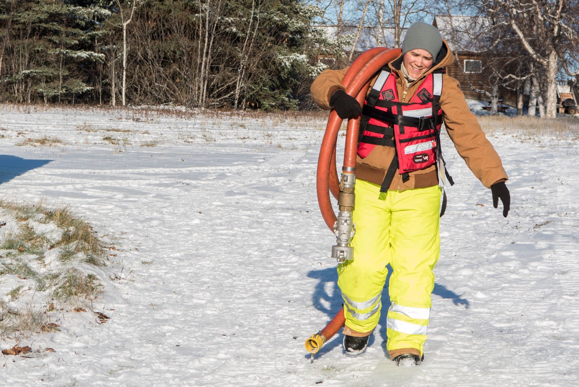 U.S. Air Force Staff Sgt. Angelica Figueroa, 611th Civil Engineer Squadron structural journeyman, carries a hose during the annual Fall Spill Drill at Joint Base Elmendorf-Richardson, Alaska, Oct. 30, 2018. The exercise tested the response actions of base recovery agencies in the event of a mass fuel spill, to ensure installation safety and minimize environmental impact.