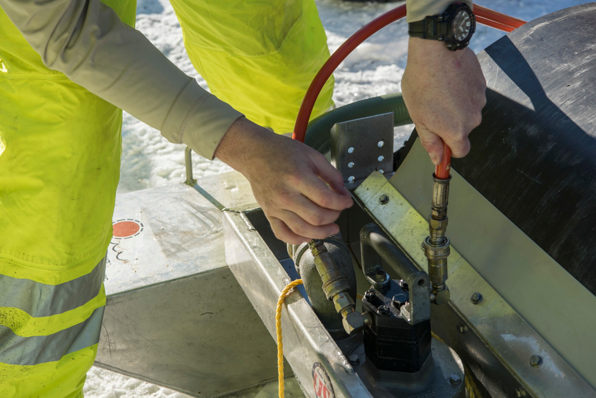 U.S. Air Force Tech Sgt. Kipp Baldwin, 611th Civil Engineer Squadron maintenance contracts, attaches a hose to a containment drum during the annual Fall Spill Drill at Joint Base Elmendorf-Richardson, Alaska, Oct. 30, 2018. The exercise was conducted to test the response actions of base recovery agencies in the event of a mass fuel spill, to ensure installation safety and minimal environmental impact.