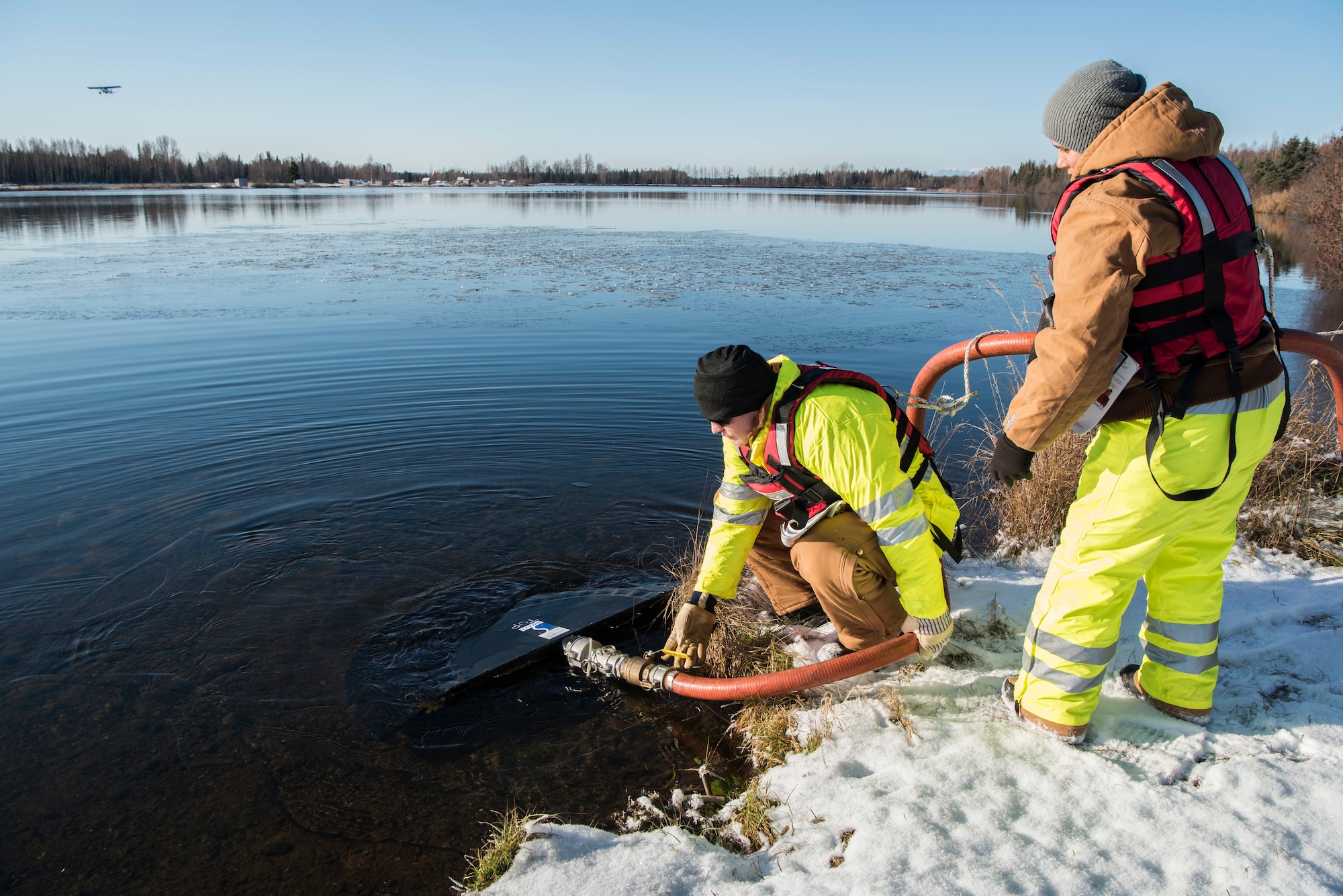U.S. Air Force Staff Sgt. Clayton Cook, 611th Civil Engineer Squadron water, fuels and system maintenance quality assurance, and Staff Sgt. Angelica Figueroa, 611th CES structural journeyman, test a skimmer during the annual Fall Spill Drill at Joint Base Elmendorf-Richardson, Alaska, Oct. 30, 2018. The exercise was conducted to test the response actions of base recovery agencies in the event of a mass fuel spill, to ensure installation safety and minimal environmental impact.