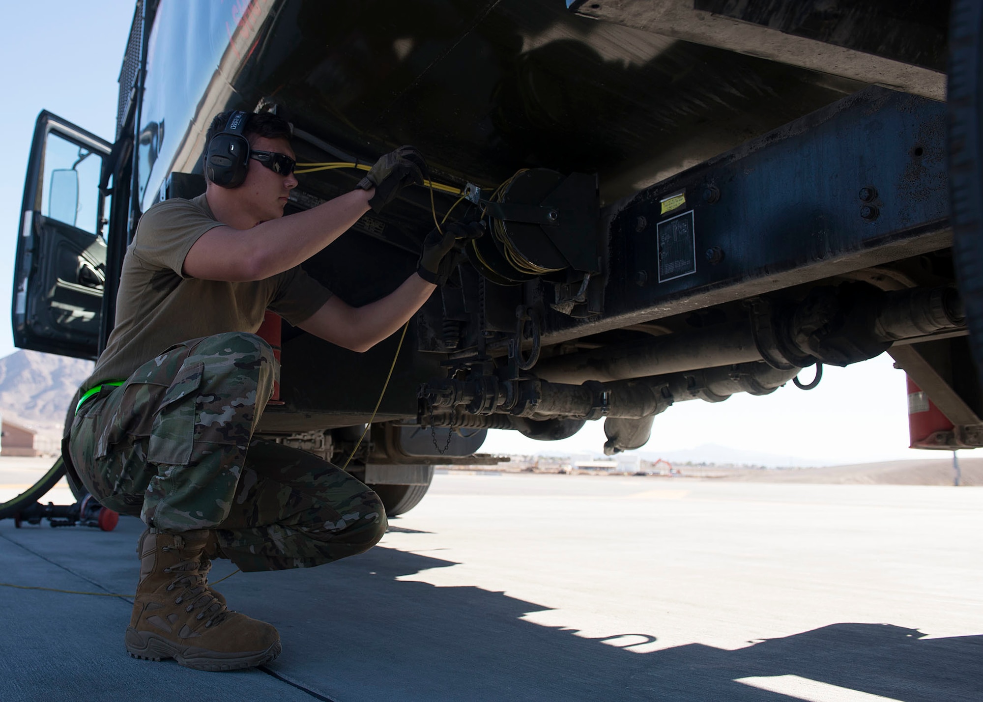 Airman 1st Class Joseph Main, 99th Logistics Readiness Squadron fuels distribution operator, rolls up wiring underneath this refueling tanker on Neliis Air Force Base, Nov. 7, 2018. Hot-pit refueling is required as annual training for 99th LRS members. (U.S. Air Force photo by Airman 1st Class Bryan T. Guthrie)