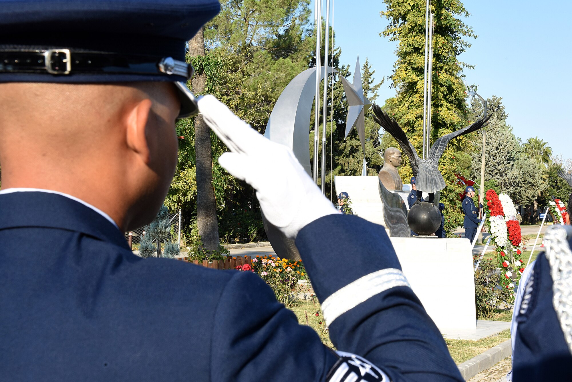 Honor Guard Airman salutes during a memorial ceremony.