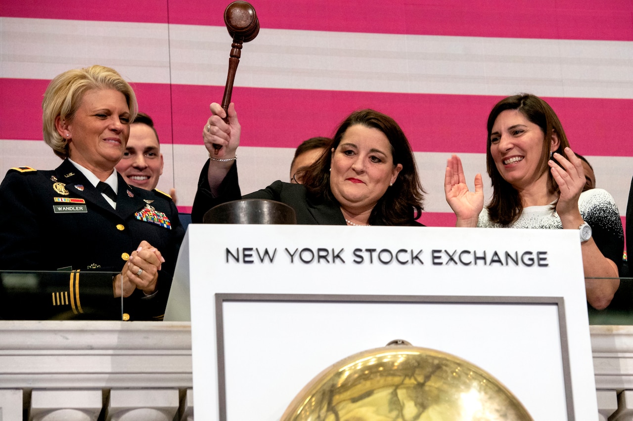 A woman stands behind a podium at the New York Stock Exchange, preparing to ring the close of business bell.