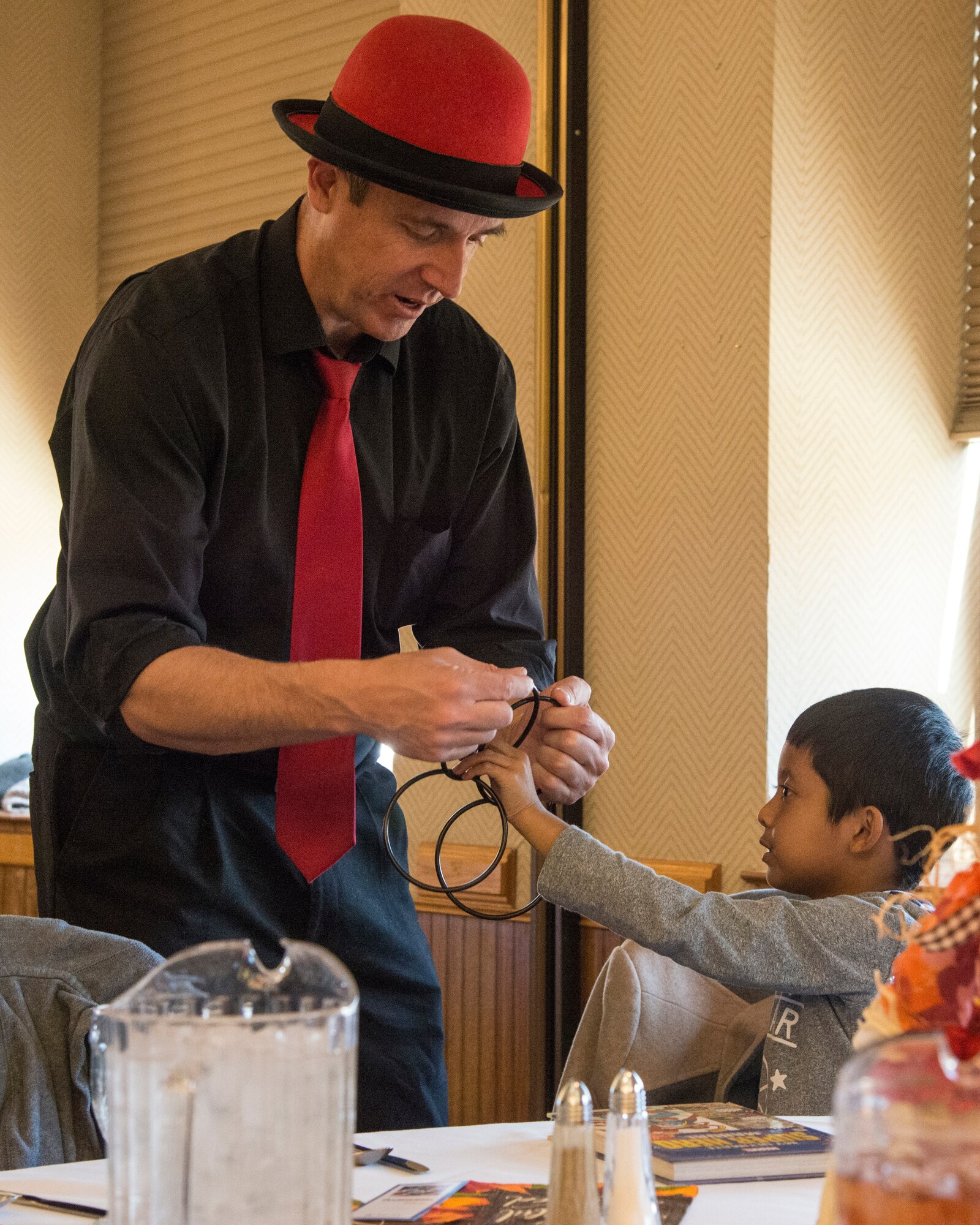 Tall Pall the Magician entertains Liam Jimenez, 6, at the Thanksgiving luncheon Oct. 10 at the Mountain View Club. This lunchoen in years past was the traditional event scheduled for the families of deployed members, but was opened this year to the rest of Team Kirtland to increase support for deployed families. Patrons were treated to a traditional Thanksgiving lunch followed by entertainment from Tall Paul. (U.S. Air Force photo by Jim Fisher)