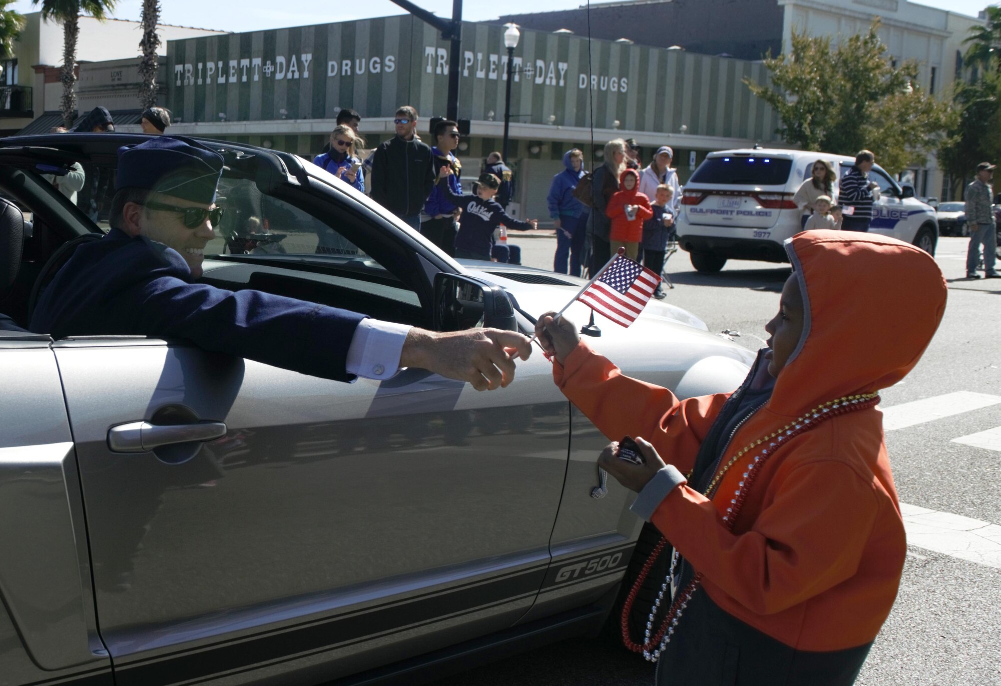 U.S. Air Force Col. Lance Burnette, 81st Training Wing vice commander, hands a U.S. Flag to Ethyn Otis during the 18th Annual Gulf Coast Veterans Day Parade in Gulfport, Mississippi, Nov. 10, 2018. Keesler Air Force Base leadership along with hundreds of Airmen attended and participated in the parade in support of all veterans past and present. More than 70 unique floats, marching bands and military units marched in the largest Veterans Day parade on the Gulf Coast. (U.S. Air Force photo by Kemberly Groue)