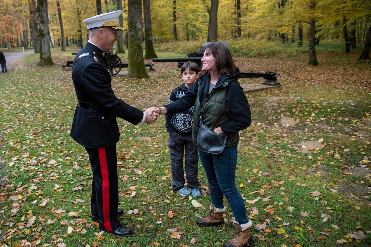 Marine Corps Gen. Joe Dunford, chairman of the Joint Chiefs of Staff, shakes the hand of a woman standing with a child.