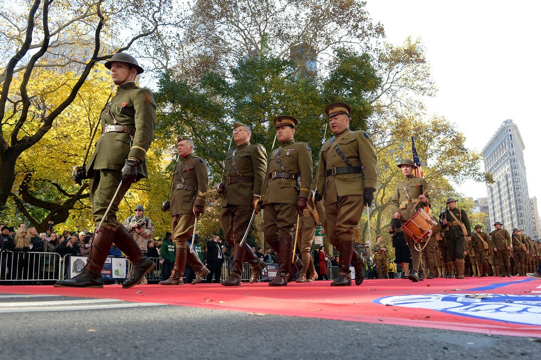 WWI reenactors in uniform march in a parade