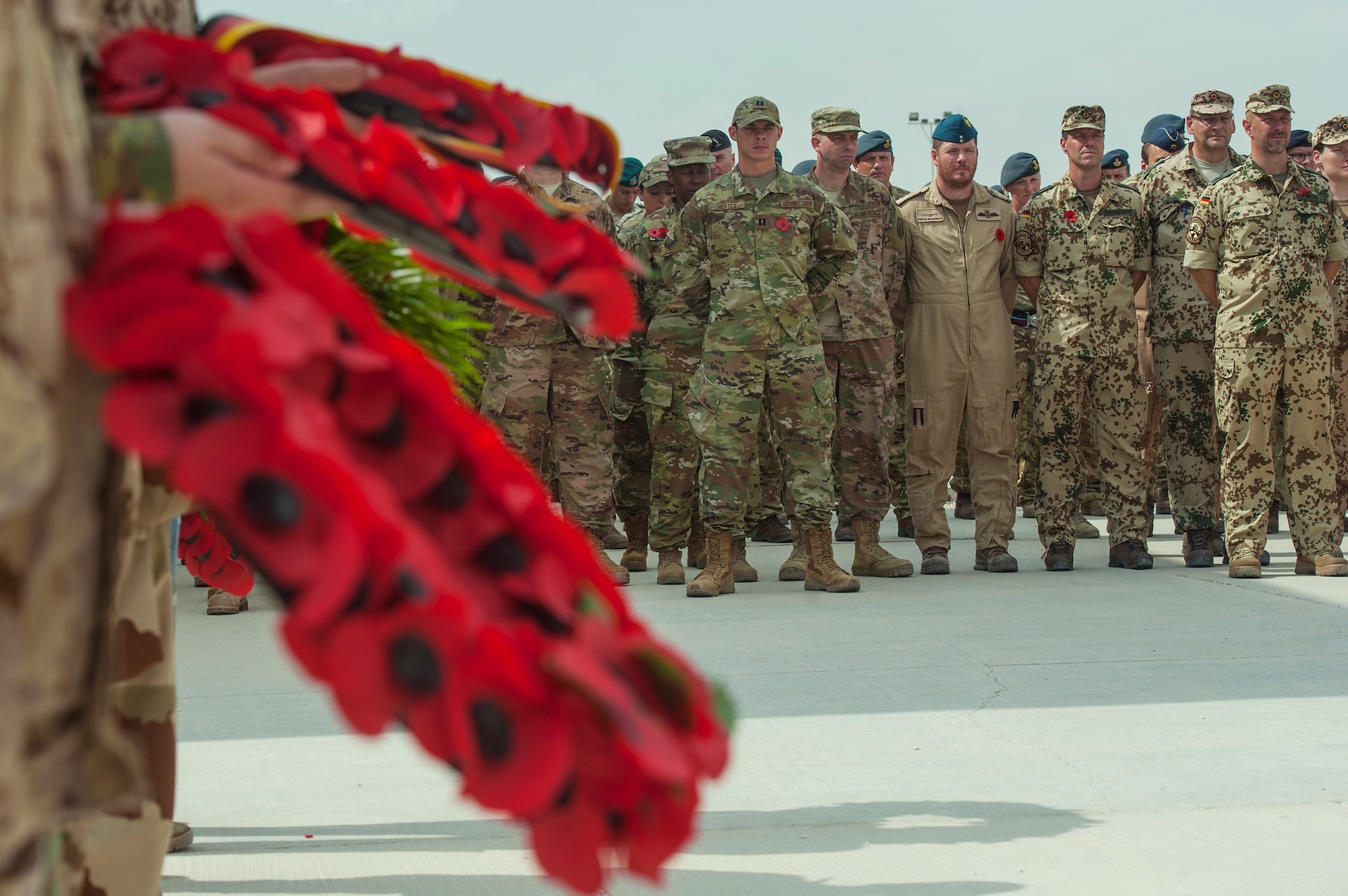 Service members stand in a multinational formation during a Service of Remembrance Nov. 11, 2018, at Al Udeid Air Base, Qatar. Members of the Royal Air Force hosted the event, organizing the involvement of 15 nations’ military members. The service marked 100 years since the end of World War I. (U.S. Air Force photo by Tech. Sgt. Christopher Hubenthal)