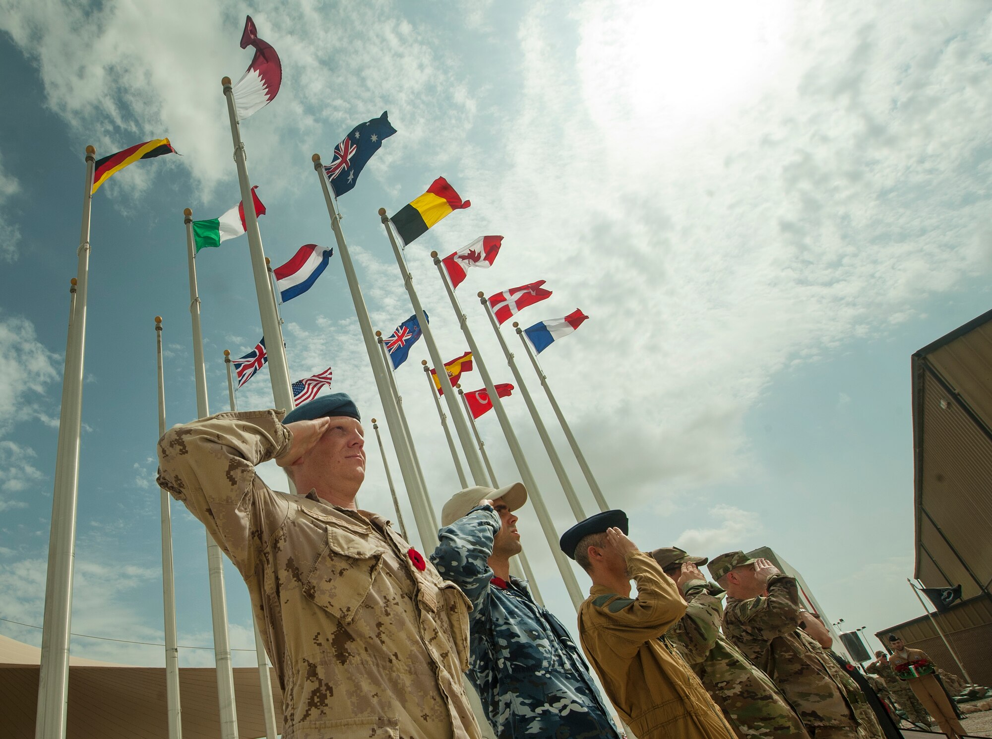 A group of multinational service members render a salute during a Service of Remembrance Nov. 11, 2018, at Al Udeid Air Base, Qatar. Members of the Royal Air Force hosted the event, organizing the involvement of 15 nations’ military members. The service marked 100 years since the end of World War I. (U.S. Air Force photo by Tech. Sgt. Christopher Hubenthal)