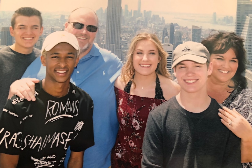 4 teens pose with parents on roof in New York City