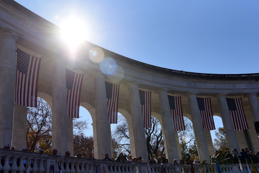 Group of people stand underneath American flags