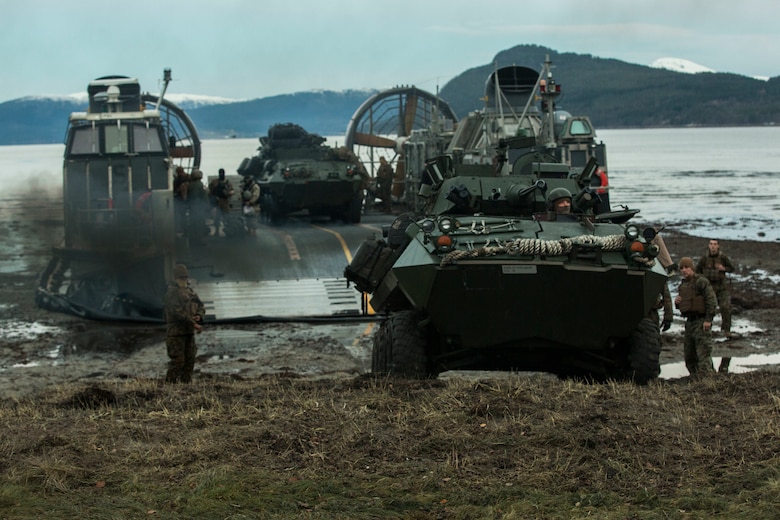 Marines and Sailors offload light armored vehicles from a landing craft air cushion on Alvund Beach, Norway during an amphibious landing in support of Trident Juncture 18, Oct. 30, 2018. Trident Juncture provides a unique environment for the Marines and Sailors to rehearse their amphibious capabilities. The LCACs originated from USS New York and showcased the ability of the Iwo Jima Amphibious Ready Group and the 24th Marine Expeditionary Unit to rapidly project combat power ashore. The vehicles and Marines are with 2nd Light Armored Reconnaissance Battalion, 24th MEU.