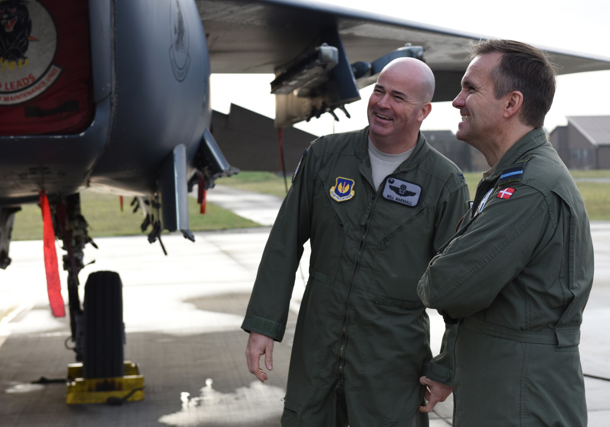 U.S. Air Force Col. William Marshall, 48th Fighter Wing commander (left), and Royal Danish Air Force Chief of Air Staff Maj. Gen. Anders Rex (right), tour an F-15E Strike Eagle during a base visit at Royal Air Force Lakenheath, England, on Nov. 5, 2018. The visit entailed discussions on 4th and 5th generation aircraft interoperability. (U.S. Air Force photo by Staff Sgt. Alex Echols)