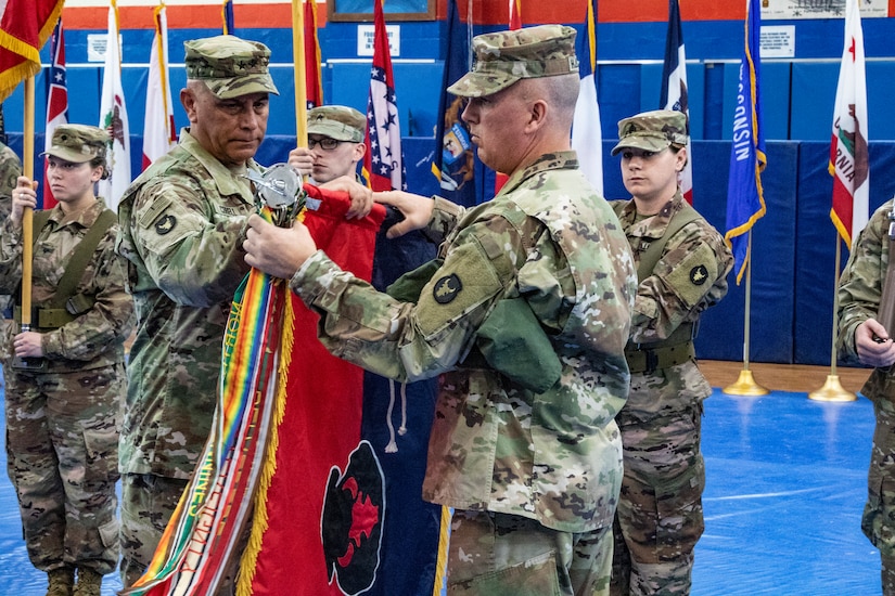 Maj. Gen. Benjamin Corell, 34th Red Bull Infantry Division commanding general and Command Sgt. Maj. Joseph Hjelmstad uncase the Division colors during a transfer of authority ceremony Nov. 12, 2018. The Minnesota National Guard unit's headquarters and headquarters battalion assumed responsibility for the Task Force Spartan mission to from the Pennsylvania National Guard's 28th Infantry Division. The 34th's HHBN is serving as a division headquarters for roughly 10,000 Soldiers conducting theater security operations in the Middle East.