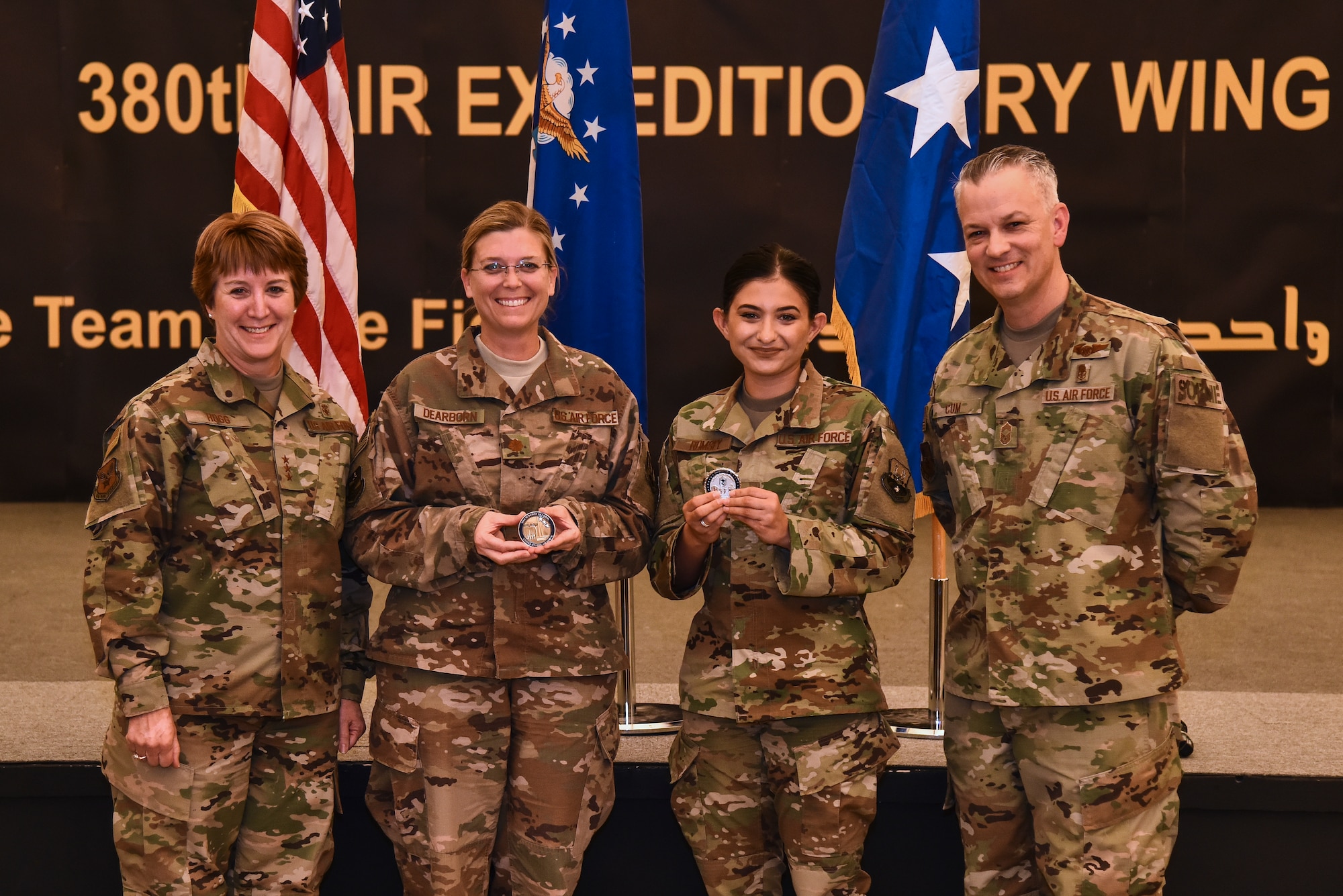 U.S. Air Force Lt. Gen. Dorothy Hogg, AF Surgeon General, and Chief Master Sgt. Steven Cum, Chief of Medical Enlisted Force and Enlisted Corps Chief, pose with two Airmen from the 380th Expeditionary Medical Group during an all-call at Al Dhafra Air Base, United Arab Emirates, Nov. 11, 2018. The Airmen were coined because of their outstanding performance and contribution to the 380th Air Expeditonary Wing mission. (U.S. Air Force photo by Senior Airman Mya M. Crosby)