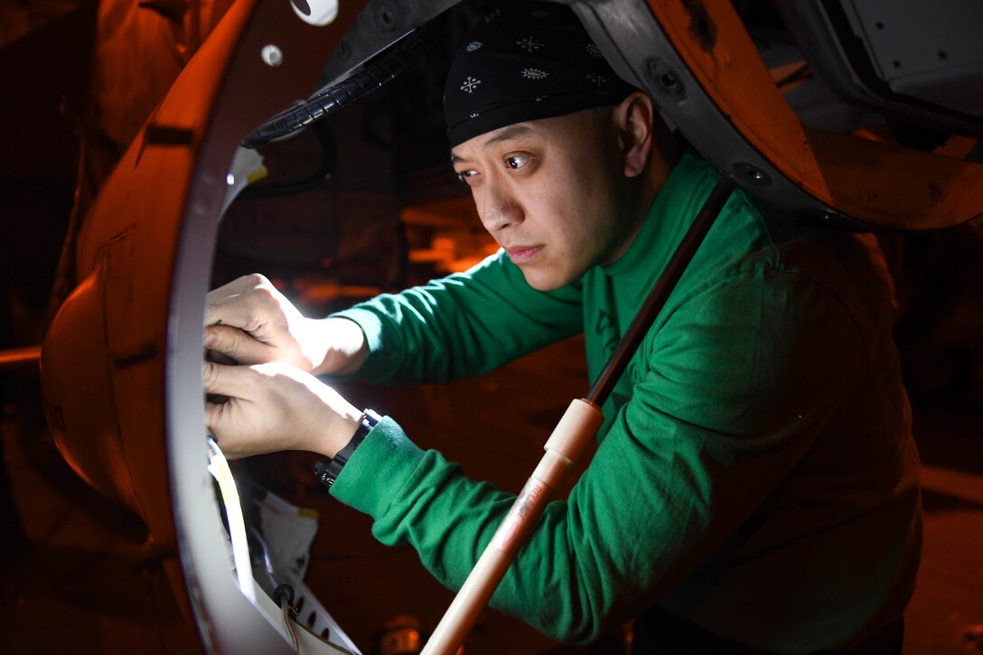 A technician works on aircraft panel