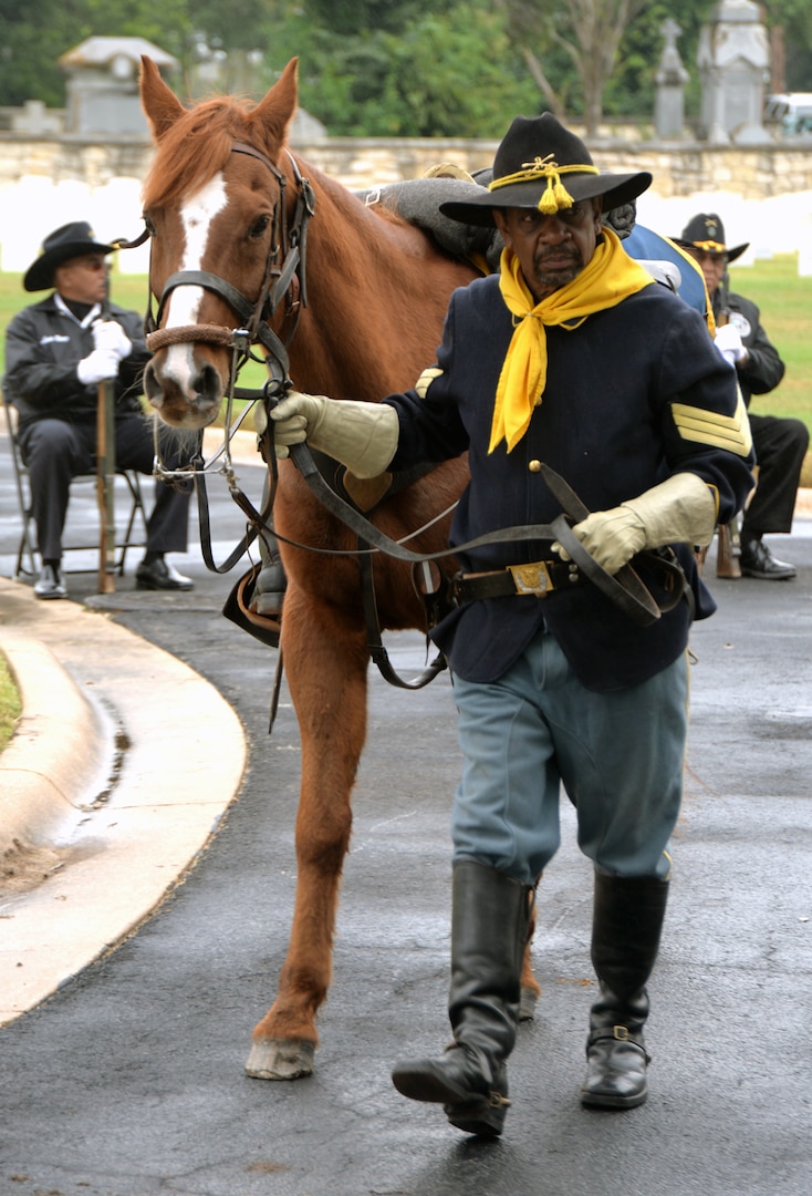 A member of the Bexar County Buffalo Soldiers leads his mount into the San Antonio National Cemetery Nov. 11 for the annual Bexar County Buffalo Soldiers Commemorative Ceremony. Comprised of former slaves, freed men and Black Civil War veterans, the historic Buffalo Soldiers persevered through the most difficult conditions imaginable to become some of the most elite and most decorated units in the U.S. Army.