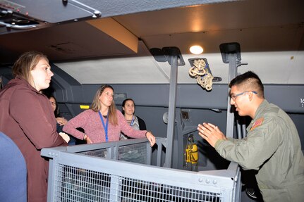 Senior Airman Andres Terrazas, 68th Airlift Squadron loadmaster, explains how crew and passengers operate in the troop compartment of a C-5M Super Galaxy to a group of recruiting influencers at Joint Base San Antonio-Lackland, Texas Nov. 8, 2018.