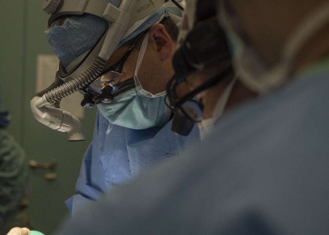 Canadian Forces Maj. Davin Schmidt, an oral surgeon from Pembroke, Ontario, performs surgery on Pedro Anton, 8, in an operating room aboard the hospital ship USNS Comfort.