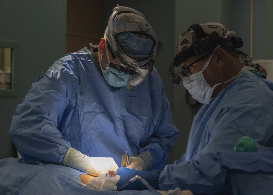 Canadian Forces Maj. Davin Schmidt, an oral surgeon from Pembroke, Ontario, performs surgery on Pedro Anton, 8, in an operating room aboard the hospital ship USNS Comfort.