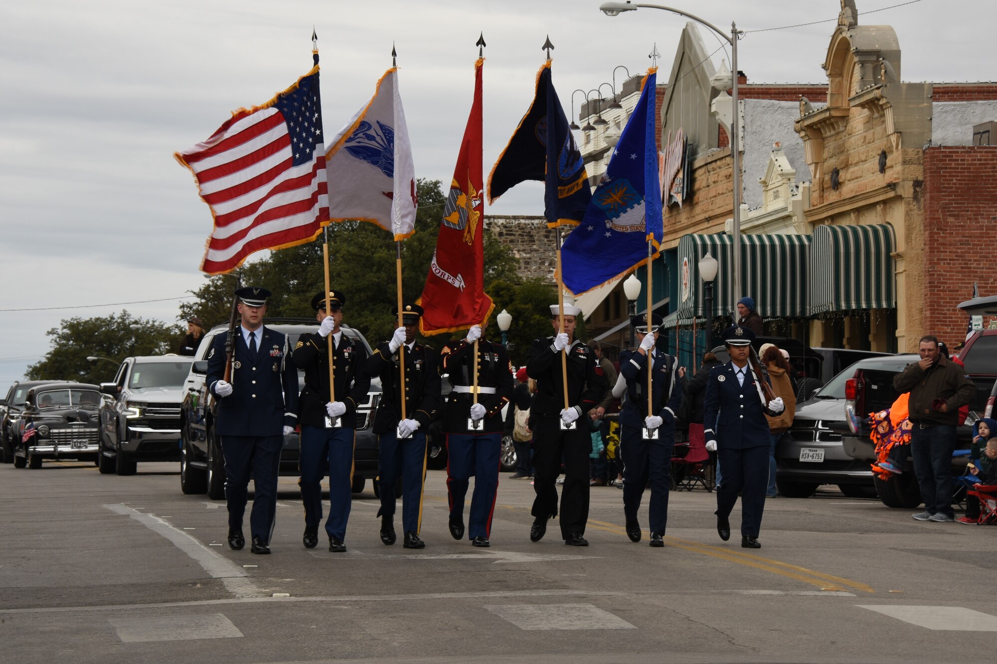 Joint Service Color Guard marches during the Veterans Day Parade in San Angelo, Texas, Nov. 10, 2018. The Joint Service Color Guard consists of members from each branch, followed by the other 400 military members participating in the parade. (U.S. Air Force photo by Airman 1st Class Zachary Chapman/Released)