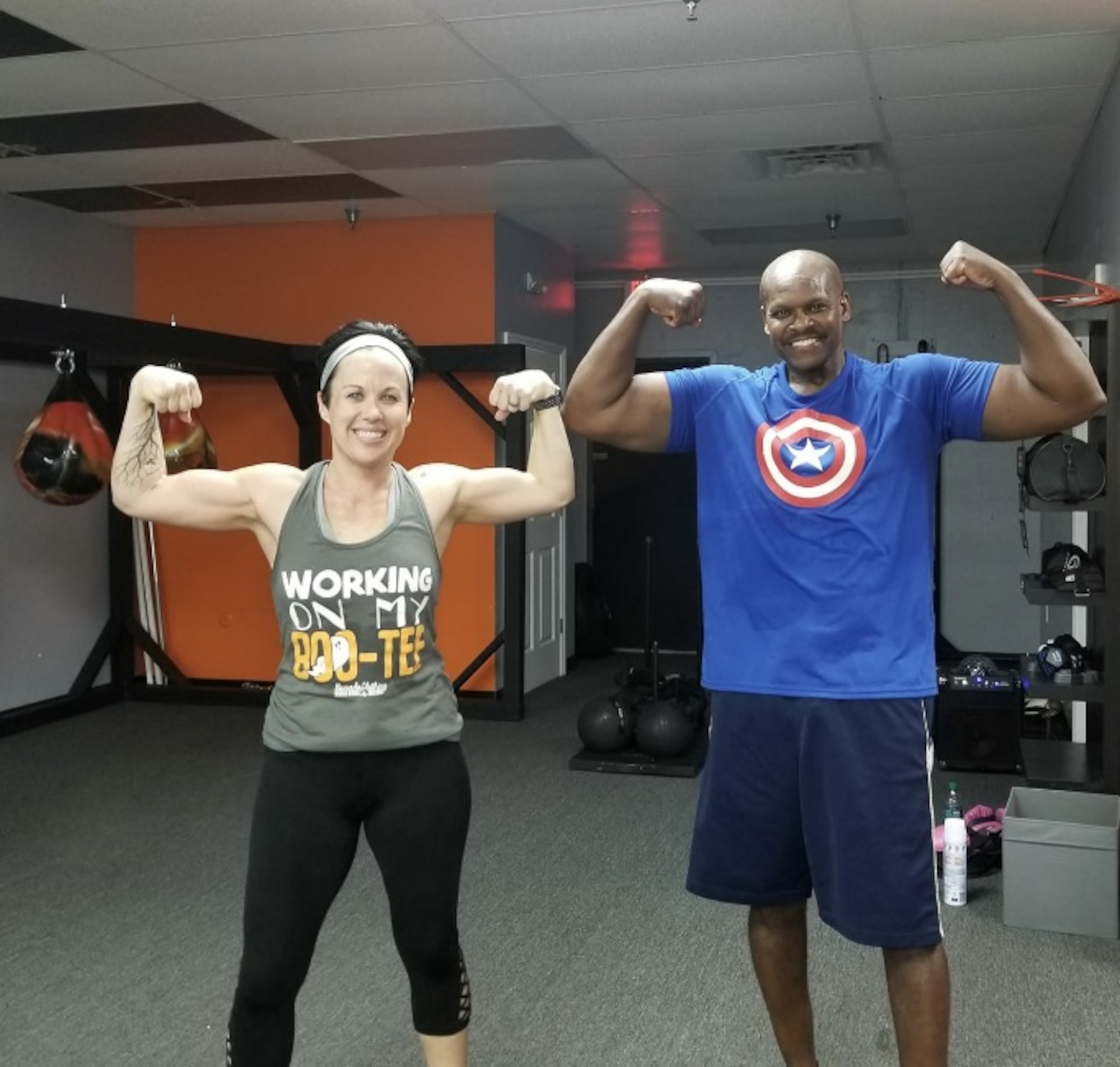 Retired Master Sgt. and financial management specialist Daryl McFadden, flexes with one of his fitness partners, Christina Millard, after a workout.  McFadden, who has survived cancer twice and undergone a triple bypass surgery, makes his health his number one priority by continuing to exercise and changing his eating habits. (Courtesy photo)