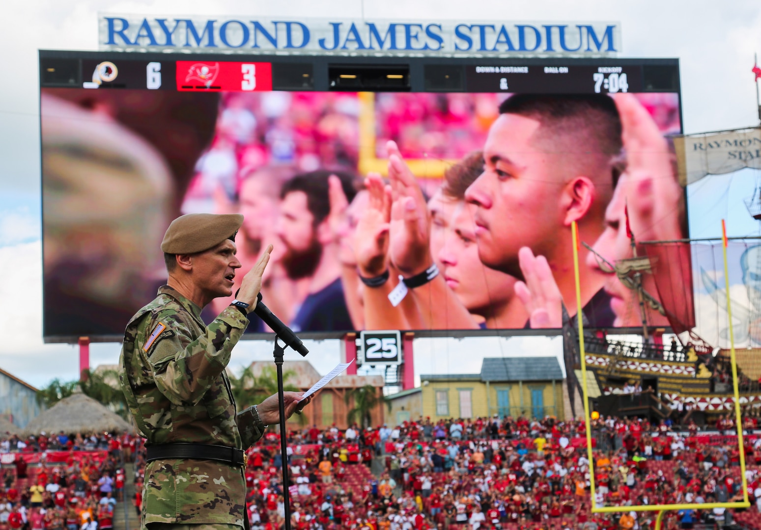 U.S. Army Gen. Joseph Votel, commander, U.S. Central Command, administers the Oath of Enlistment to approximately 130 future service members during a ceremony at Raymond James Stadium, Nov. 11th, 2018. The enlistees were provided a unique opportunity to take the Oath of Enlistment in front of thousands of football fans, during halftime of the Tampa Bay Buccaneers home game versus the Washington Redskins. (U.S. Central Command Public Affairs photo by Tom Gagnier)
