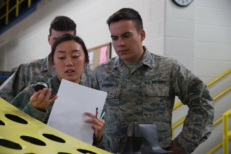 Cadets Mai-Lin Quinto and Lucas Echeverry, from the U.S. Air Force Academy, Colorado, inspect a tool designed to measure the depth of corroded pits on aircraft metals Oct. 23, 2018, at Peterson Air Force Base, Colorado.