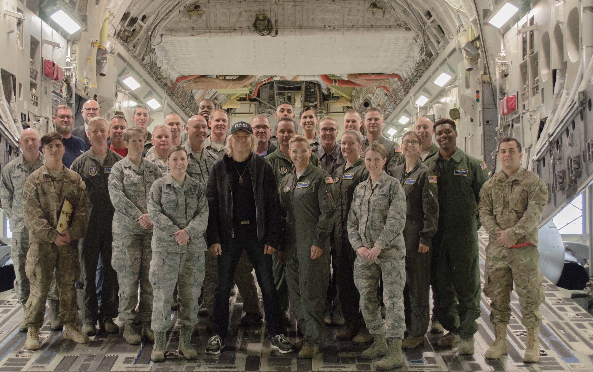 Personnel assigned to Joint Base Lewis-McChord, Wash., pose for a photograph with iconic rock n’ roll musician Joe Walsh Nov. 7, 2018. Walsh was in the area for a concert benefiting military veterans. (U.S. Air Force photo by Senior Master Sgt. Sherri Nordin)