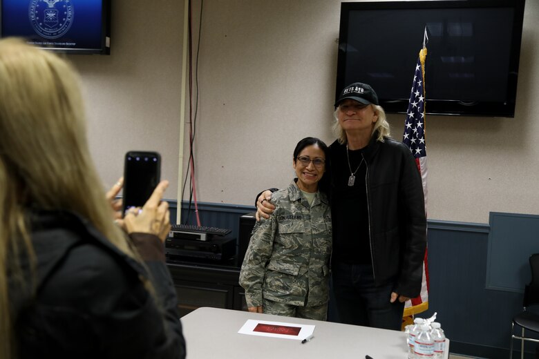 Tech. Sgt. Corina Gonzalez King pose for a photograph with Joe Walsh on Joint Base Lewis-McChord, Wash., Nov. 7, 2018. Walsh gave an impromptu performance in the terminal. (U.S. Air Force photo by David L. Yost)