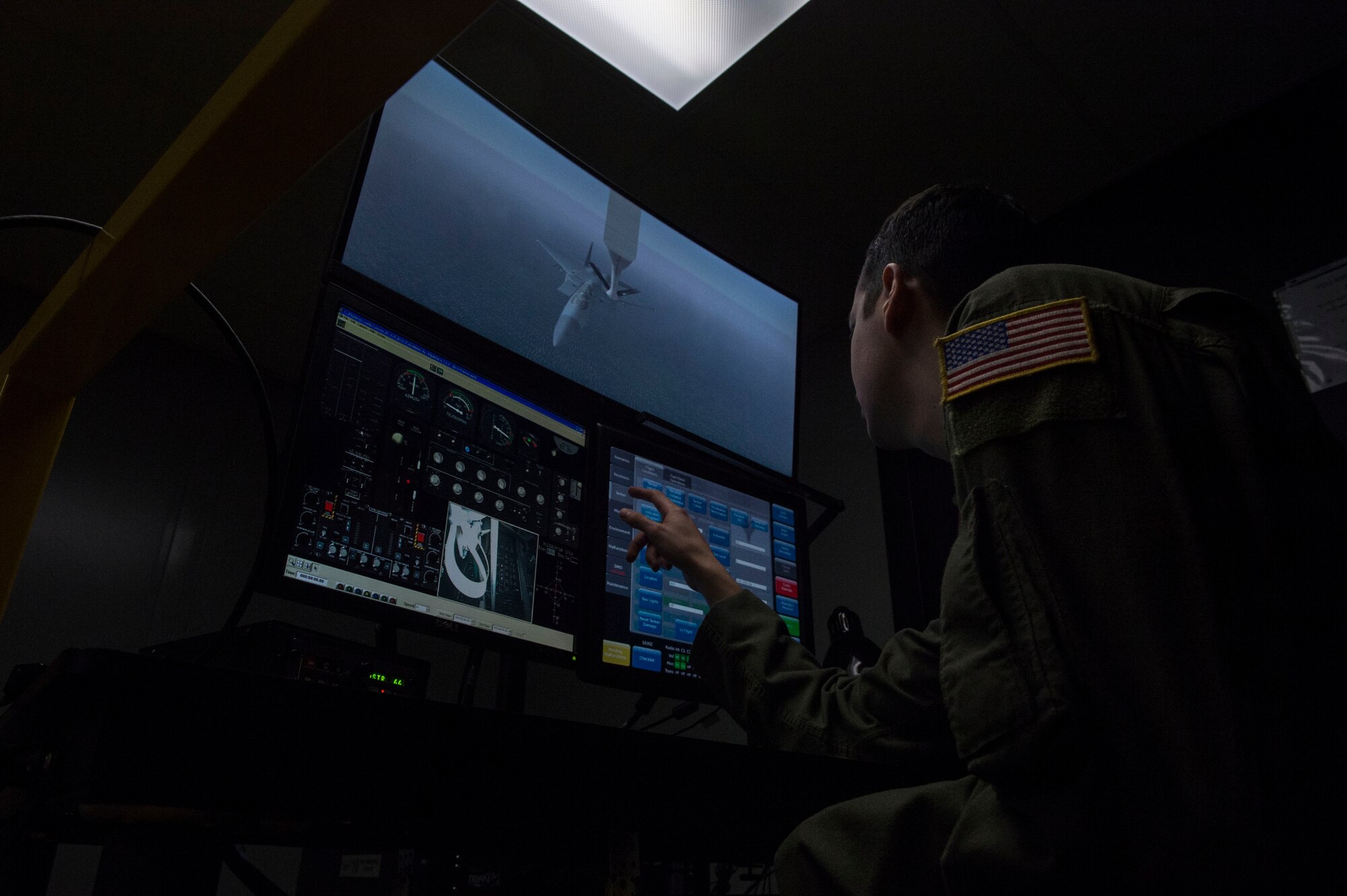 U.S. Air Force Staff Sgt. Logan Lord, a boom operator assigned to the 54th Air Refueling Squadron, adjusts the settings on the KC-135 Boom Operator Weapon System Trainer