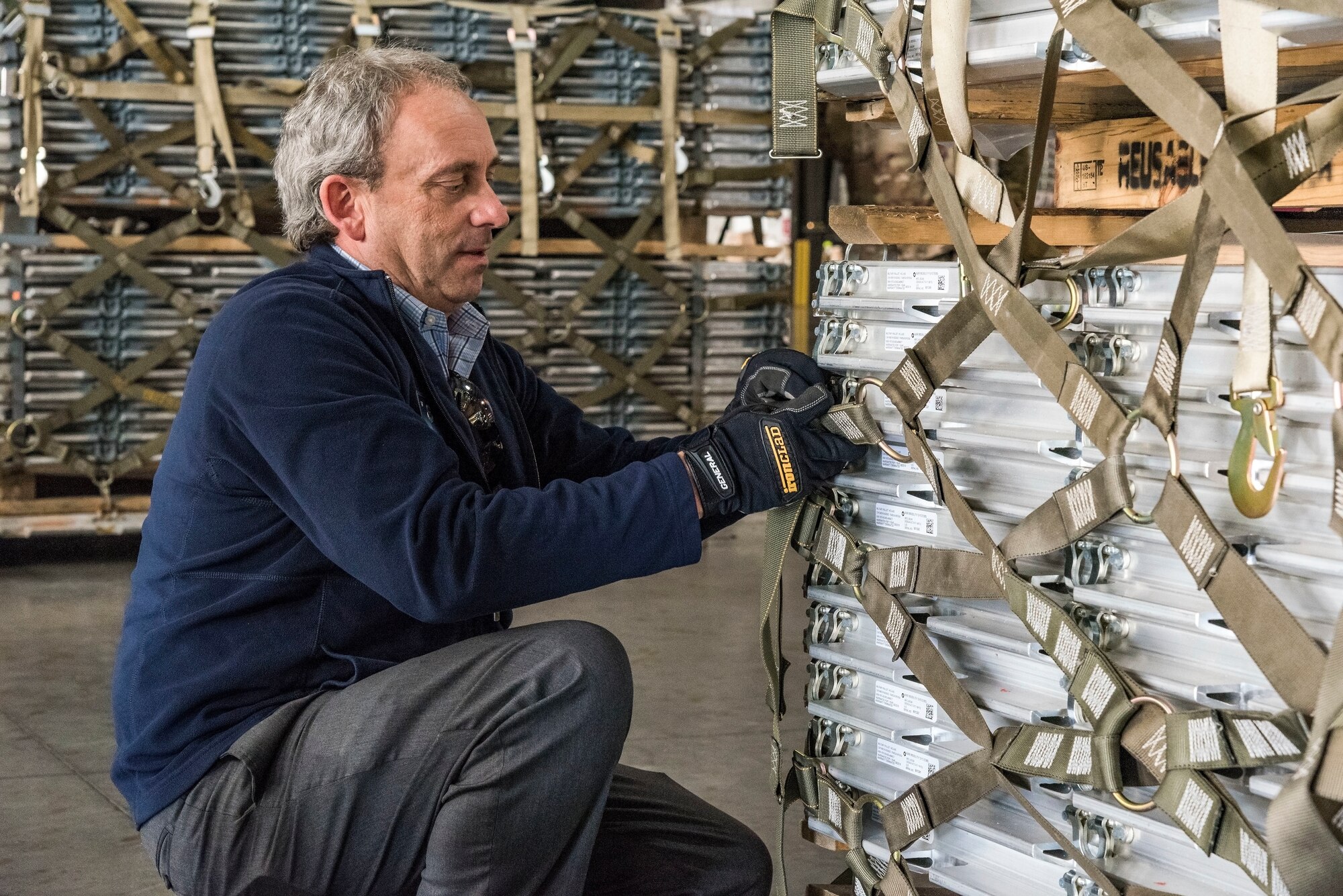 Todd Mielke, Air Mobility Command civic leader from Fairchild Air Force Base, Wash., secures cargo netting on a  pallet Nov. 7, 2018, at Dover Air Force Base, Del. Near the end of their tour of the 436th Aerial Port Squadron, Mielke and other civic leaders were divided into teams and participated in a contest to determine who could properly attach cargo netting on a pallet under the guidance of “Port Dawgs.” (U.S. Air Force photo by Roland Balik)