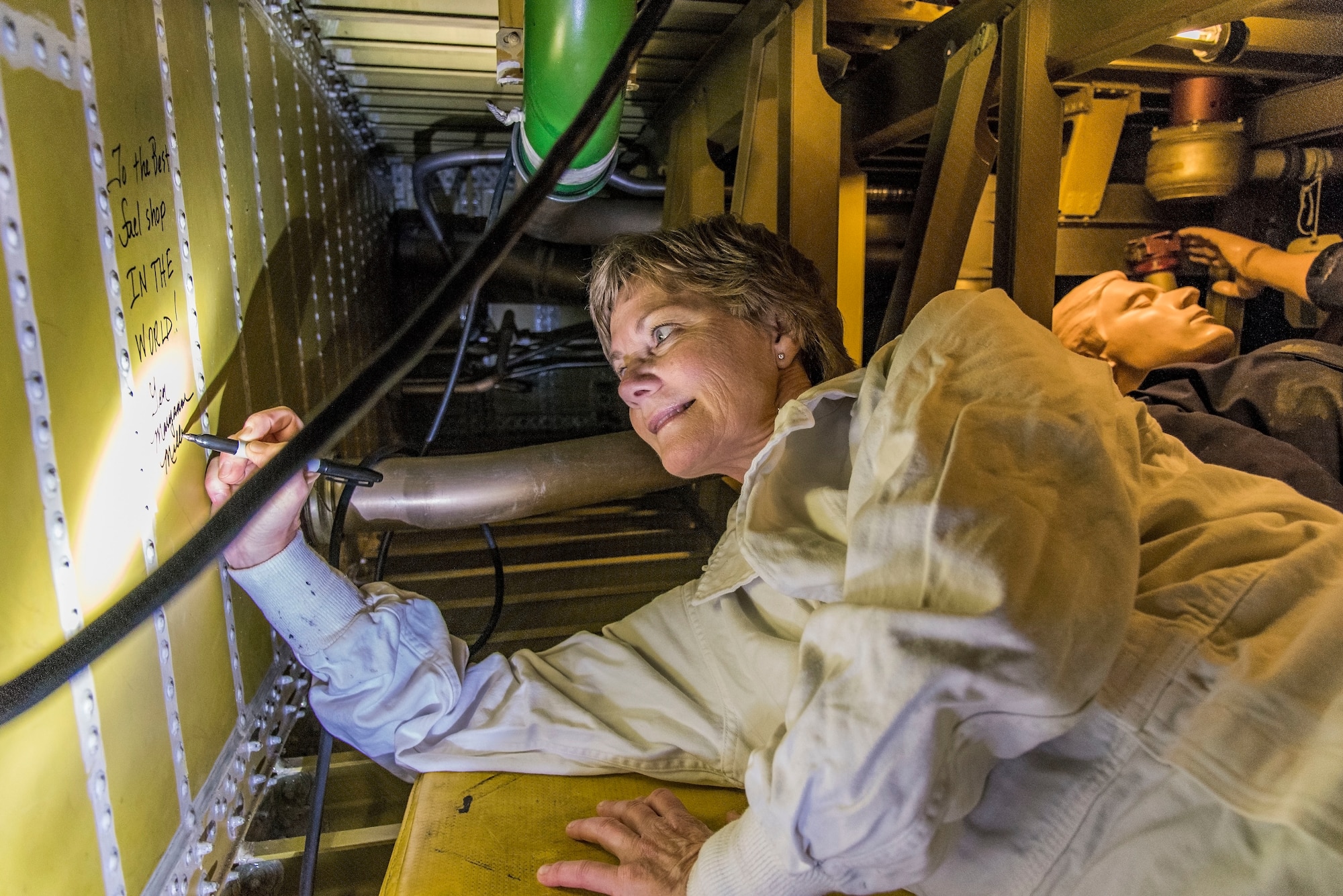 Gen. Maryanne Miller, Air Mobility Command commander, signs her name after writing a message on the inside of a C-5B Galaxy auxiliary fuel tank Nov. 7, 2018, at Dover Air Force Base, Del. This actual wing fuel tank is used by the 436th Maintenance Squadron Fuel Cell personnel and base first responders for worker extraction training. (U.S. Air Force photo by Roland Balik)