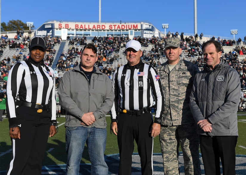 U.S. Air Force Col. Sean Tyler, 633rd Air Base Wing commander, poses with retired U.S. Navy Petty Officer 2nd Class Brian Graves and members from the Old Dominion University Monarchs football program before a football game at ODU in Norfolk, Virginia, Nov. 10, 2018.