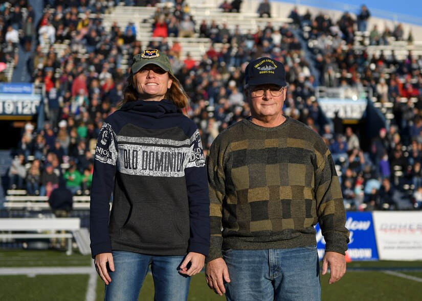 U.S. Air Force Lt. Col. Aasta Pedersen, 633rd Surgical Operations Squadron surgeon, and retired U.S. Navy Senior Chief Petty Officer Eric Pedersen, stand on Foreman Field during a Veterans Day tribute at Old Dominion University in Norfolk, Virginia, Nov. 10, 2018.
