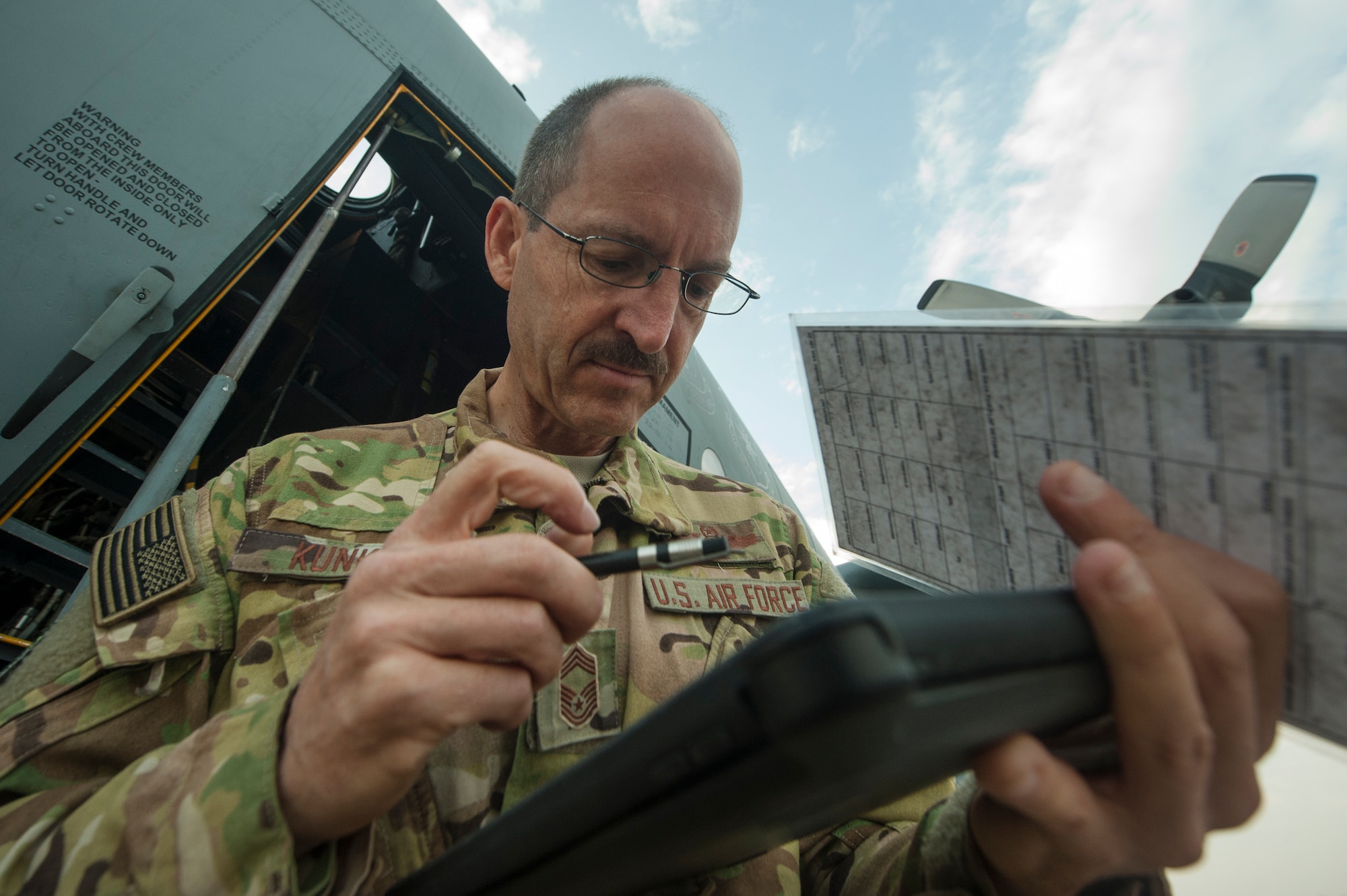 U.S. Air Force Reserve Chief Master Sgt. Kenneth Kunkel, 746th Expeditionary Airlift Squadron flight engineer, processes paperwork for a C-130 Hercules pre-flight inspection Nov. 13, 2018, at Al Udeid Air Base, Qatar. Kunkel reached 10,000 flying hours Oct. 6, 2018 a number considered prestigious amongst military aviators. (U.S. Air Force photo by Tech. Sgt. Christopher Hubenthal)