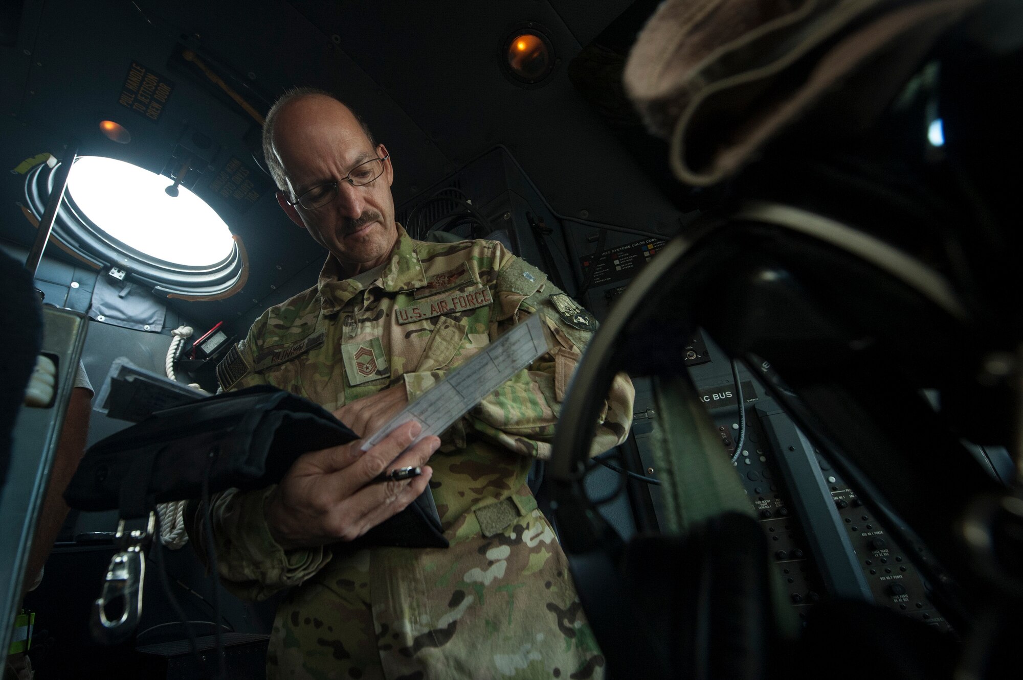 U.S. Air Force Reserve Chief Master Sgt. Kenneth Kunkel, 746th Expeditionary Airlift Squadron C-130 Hercules flight engineer, processes paperwork for a C-130 Hercules pre-flight inspection Nov. 13, 2018, at Al Udeid Air Base, Qatar. Kunkel reached 10,000 flying hours Oct. 6, 2018, a number considered prestigious amongst military aviators. (U.S. Air Force photo by Tech. Sgt. Christopher Hubenthal)