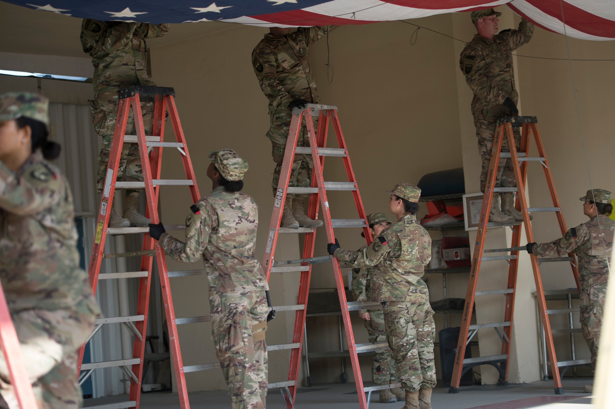 On Veterans Day, Col. Robert York, commander of the 455th Expeditionary Medical Group at Bagram, led a group of Airmen in a ceremony to remove and replace the large flag that hangs at the Craig Joint Theater Hospital Nov. 11.