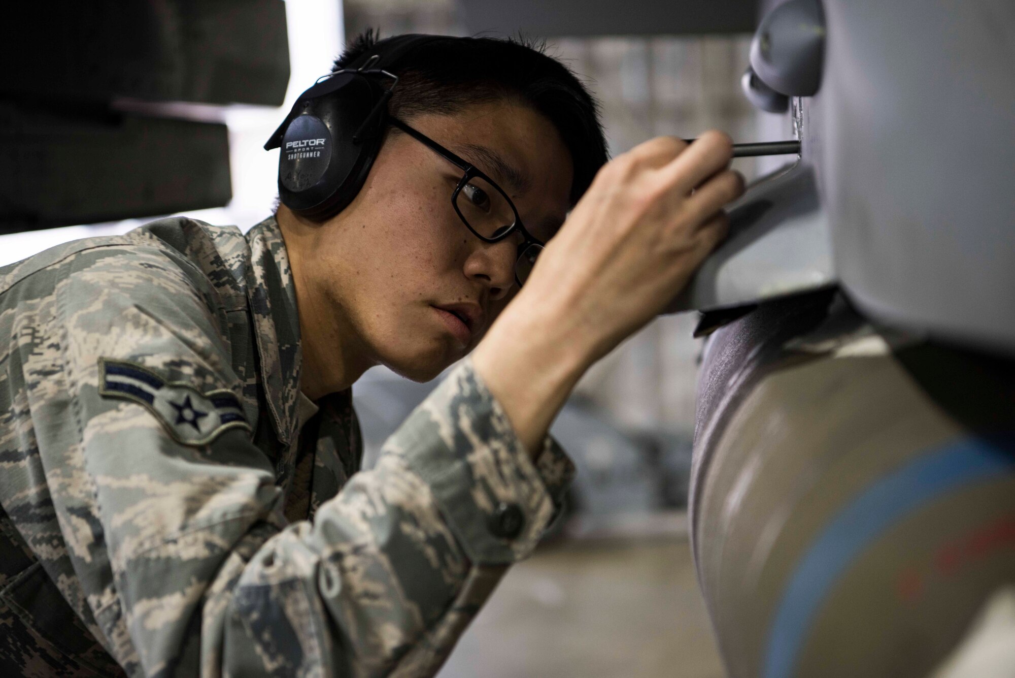 U.S. Air Force Airman 1st Class Aaron Yogi, a 14th Aircraft Maintenance Unit load crew member, performs a mechanical inspection with a pin during the third quarter load competition at Misawa Air Base, Japan, Nov. 9, 2018. This crucial step ensures loaded munitions are properly secured onto the aircraft. (U.S. Air Force photo by Airman 1st Class Collette Brooks)