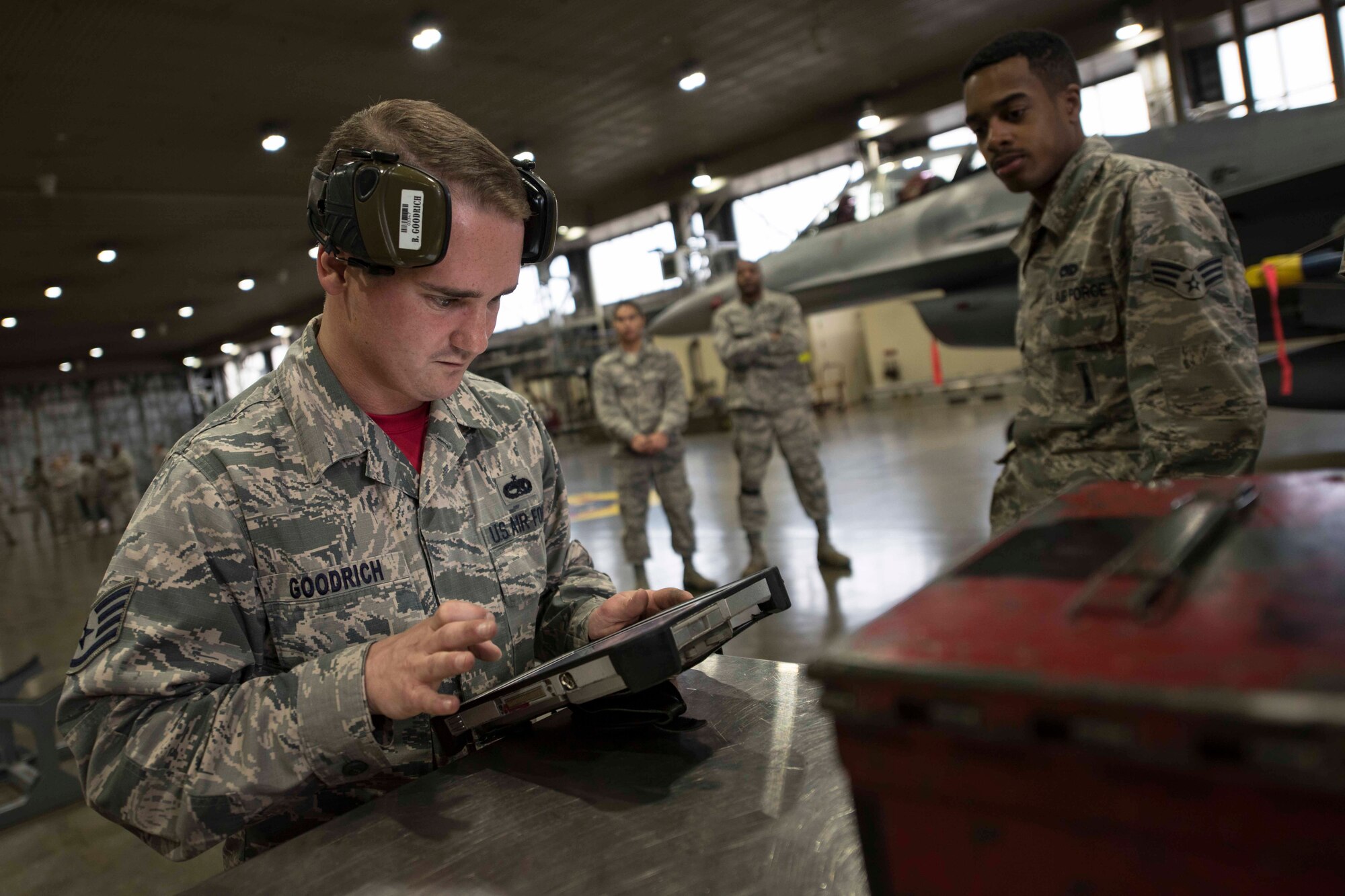U.S. Air Force Staff Sgt. Branden Goodrich, left, a load crew team chief, and Senior Airman Travonne Lindsay, right, a load crew member, both with the 13th Aircraft Maintenance Unit, review technical orders during the third quarter load competition at Misawa Air Base, Japan, Nov. 9, 2018. During the competition, Airmen raced against the clock to see which team could efficiently and accurately load munitions onto an F-16 Fighting Falcon. (U.S. Air Force photo by Airman 1st Class Collette Brooks)