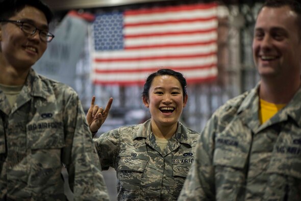 U.S. Air Force Senior Airman Jessica Ho, center, a load crew member, smiles while holding up the 14th Fighter Squadron call sign, “wood,” while Airman 1st Class Aaron Yogi, left, a load crew member, and Staff Sgt.Thad Hansen, right, a load crew chief, laugh during the third quarter load competition at Misawa Air Base, Japan, Nov. 9, 2018. Ho, Yogi and Hansen serve with the 14th Aircraft Maintenance Unit and won the competition after receiving 10 less demerits than the 13th AMU. (U.S. Air Force photo by Airman 1st Class Collette Brooks)
