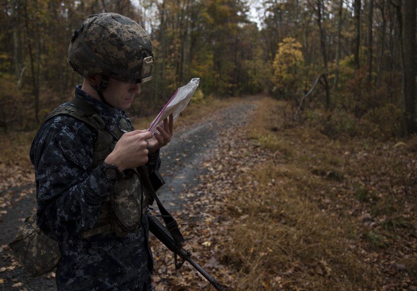U.S. Navy Airman Timothy Lavergne, 305th Operations Support Squadron air traffic controller, checks a map during the 2018 Service Member of the Year Competition on Joint Base McGuire-Dix-Lakehurst, New Jersey, Nov. 5, 2018. Using a map, compass and protractor, the competitors had three hours to plot their route, locate four separate points and return to the starting point with all equipment. (U.S. Air Force photo by Airman 1st Class Ariel Owings)
