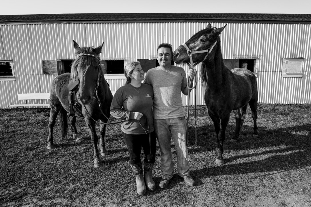 Tiffany Wisley, Langley Saddle Club head feeder, and U.S. Air Force Staff Sgt. Cody Wisley, 83rd Network Operations Squadron boundary protection supervisor, pose for a photo with their horses Spooks and Steel at the stables on Joint Base Langley-Eustis, Virginia, April 11, 2018.