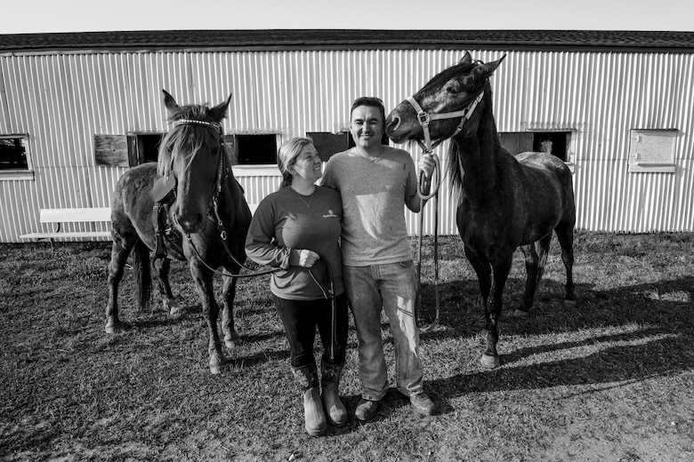 Tiffany Wisley, Langley Saddle Club head feeder, and U.S. Air Force Staff Sgt. Cody Wisley, 83rd Network Operations Squadron boundary protection supervisor, pose for a photo with their horses Spooks and Steel at the stables on Joint Base Langley-Eustis, Virginia, April 11, 2018.
