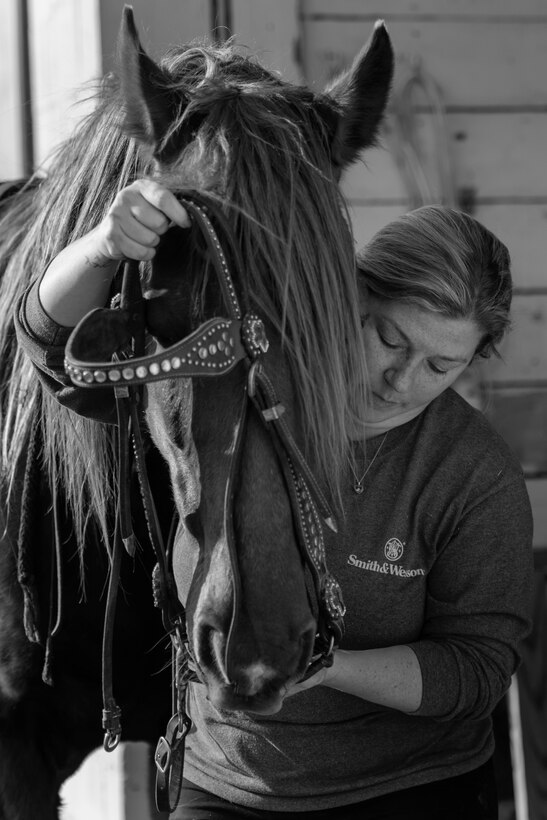 Tiffany Wisley, Langley Saddle Club head feeder, puts a bridle on her home Spooks at the stables on Joint Base Langley-Eustis, Virginia, April 11, 2018.