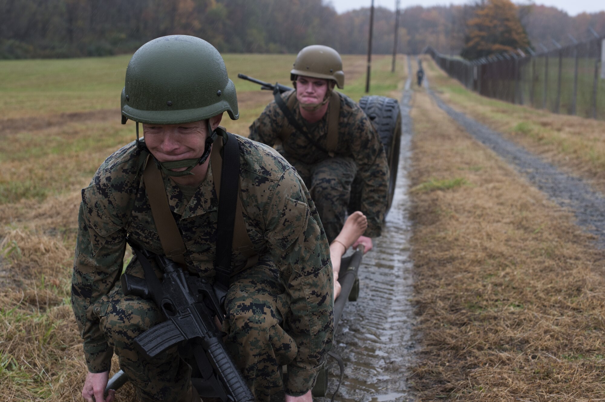 U.S. Marine Corps Staff Sgt. Lester Dickerson, Marine Light Attack Helicopter Squadron 773 aerial observer, and Lance Cpl. Cameron A. Schimmel, Marine Aircraft Group 49 aviation supply specialist, lift a weighted stretcher during the relay race portion of the 2018 Service Member of the Year Competition on Joint Base McGuire-Dix-Lakehurst, New Jersey, Nov. 5, 2018. The race required the competitors to team up and transport approximately 300 pounds over .8 miles under an hour. (U.S. Air Force photo by Airman 1st Class Ariel Owings)