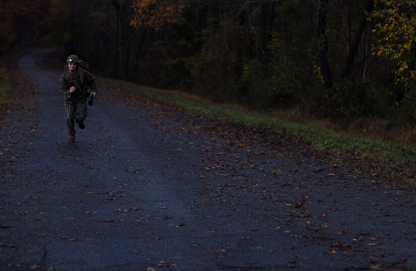 Lance Cpl. Cameron A. Schimmel, Marine Aircraft Group 49 aviation supply specialist, runs to the finish line of a six-mile ruck march during the 2018 Service Member of the Year Competition on Joint Base McGuire-Dix-Lakehurst, New Jersey, Nov. 7, 2018. Each competitor was required to have a ruck sack weighing at least 35 pounds minimum, a full water canteen, an M4 Carbine Rifle, reflective belt, advanced combat helmet, fighting-load carrier and a flashlight. (U.S. Air Force photo by Airman 1st Class Ariel Owings)