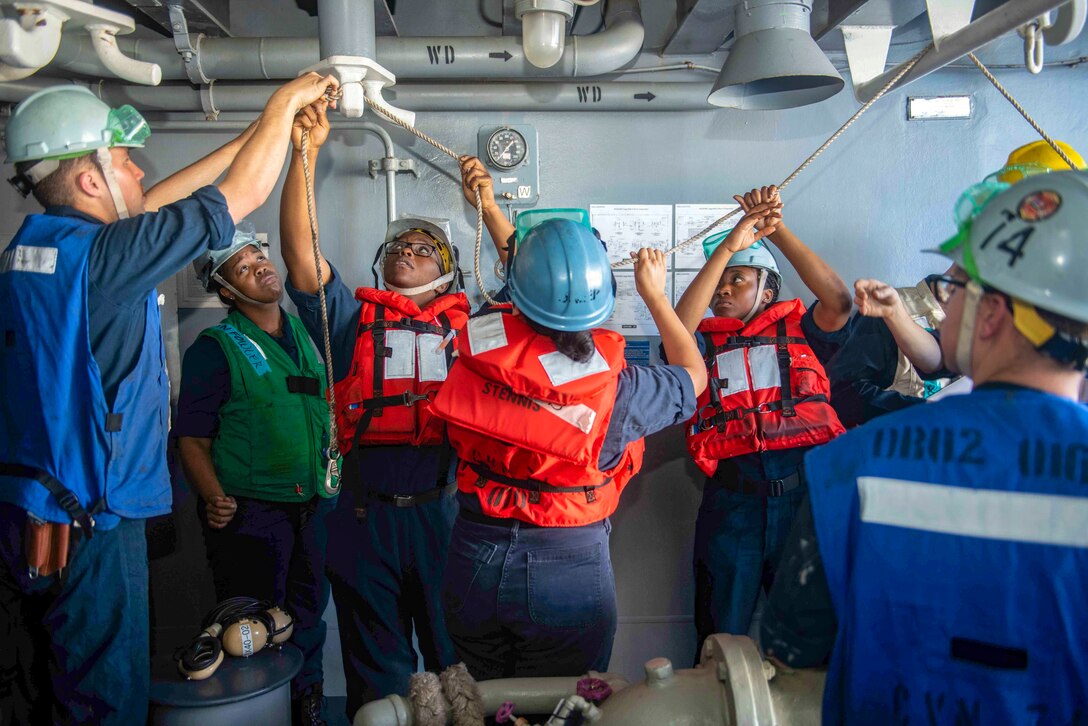 Sailors secure a line during a refueling at sea.