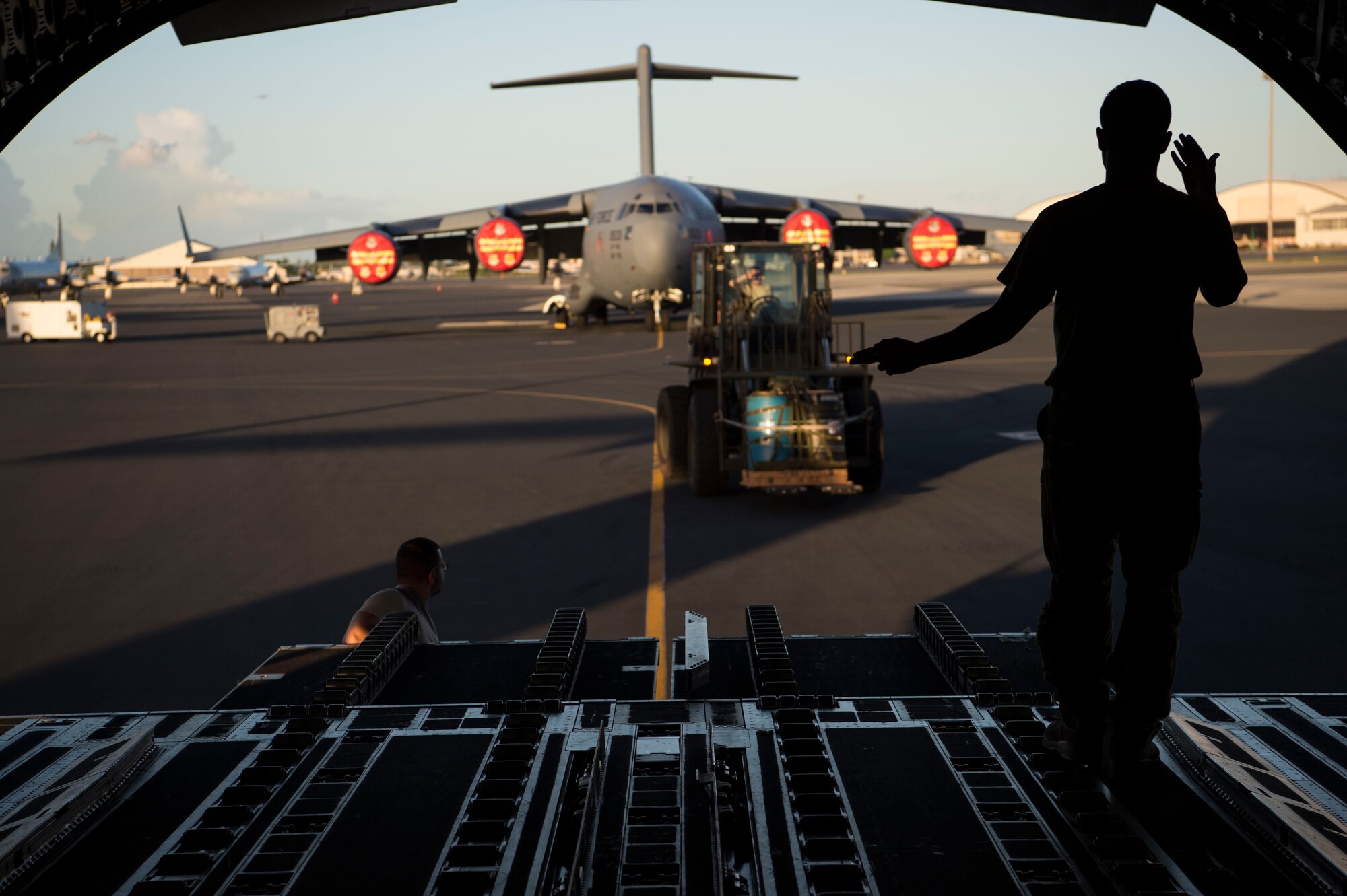 Senior Airman Trenton Turner, 535th Airlift Squadron loadmaster, guides a container delivery system onto a C-17 Globemaster III, during Big Island Drop Week, at Joint Base Pearl Harbor-Hickam, Hawaii, Hawaii, Nov. 7, 2018. During Big Island Drop Week, aircrews employed aerial delivery systems to prepare them for operations in different environments throughout the Indo-Pacific region. (U.S. Air Force photo by Tech. Sgt. Heather Redman)