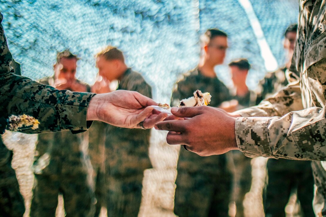 photo shows a hand with cake putting the cake in someone else's hand